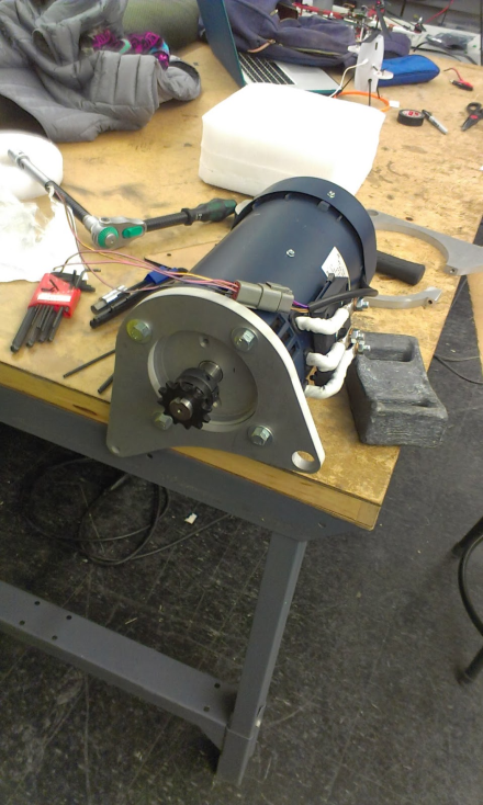 The waterjet cut motor mount attached to the front of the electric motor for the Cholocycle. Note the rear mount disassembled in the background. Photo courtesy of Robert Melendez http://rjmelendez.blogspot.com/ .